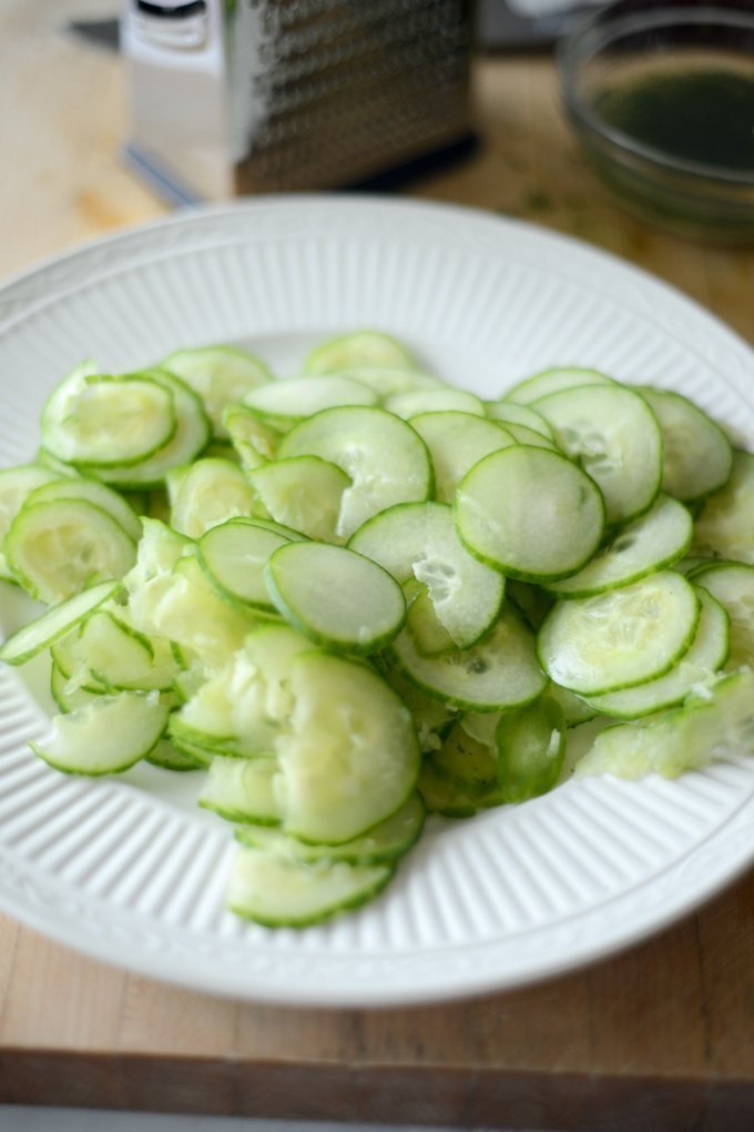 Thinly sliced cucumbers on white plate