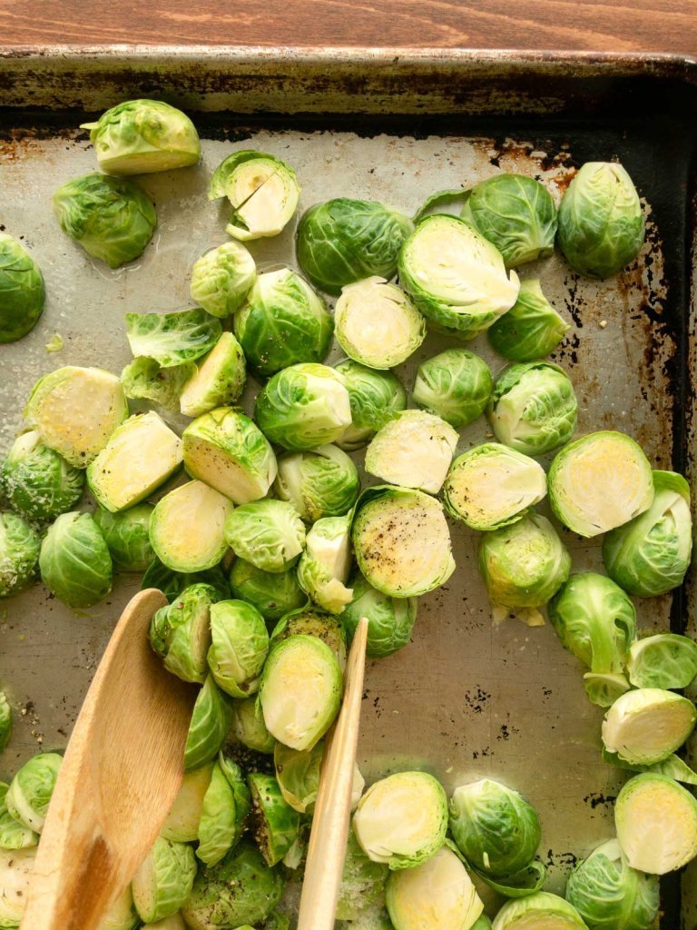 Tossing Brussels Sprouts with oil, salt and pepper.