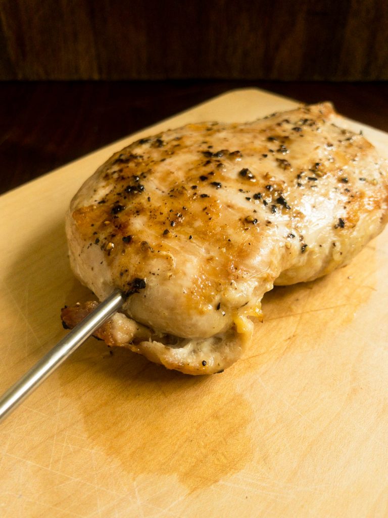 Checking the temperature of a grilled chicken breast