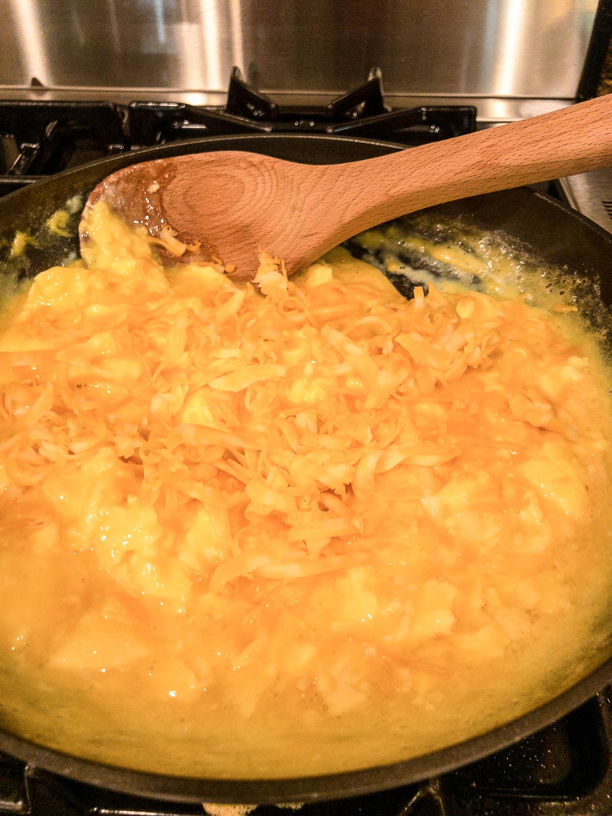 Adding cheese to scrambled eggs in a skillet